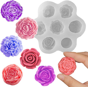 Silicone mold with rose shapes and colorful rose-shaped candies on a white background